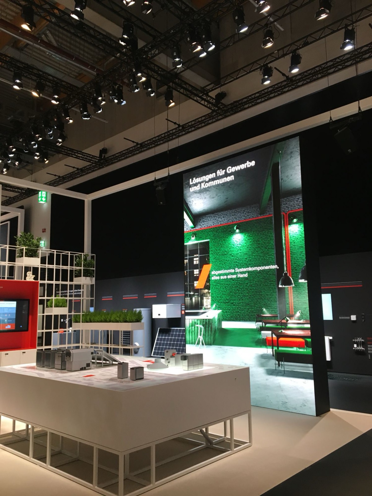 Portrait-format LED wall on a trade show stand next to an exhibit table